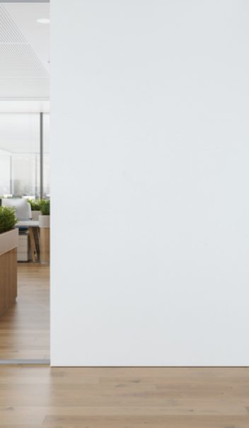 Modern Open Plan Empty Office With White Blank Wall, Tables, Computers And Plants